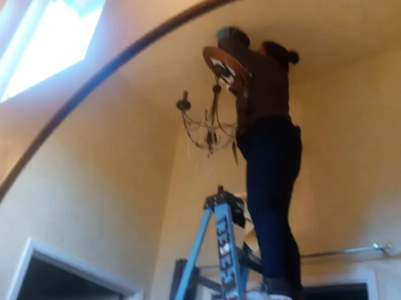 Electrician installing a chandelier in a Poughkeepsie residence